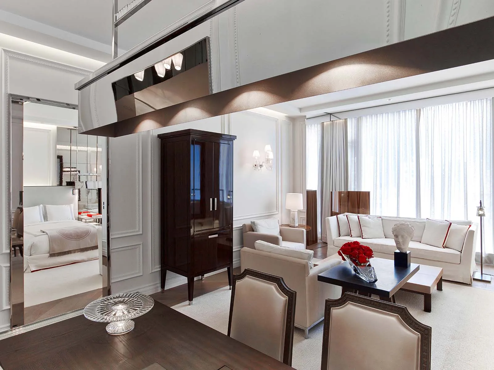 A table, pale sofa and mirrored panels in a living room