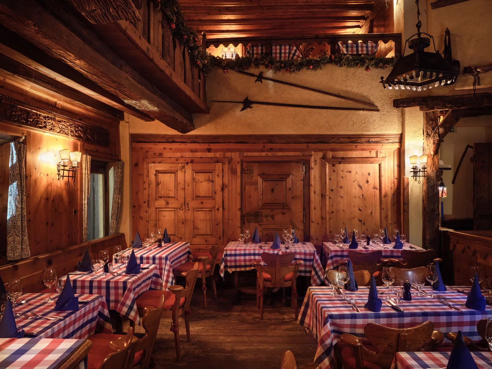 Pizzeria Heuboden in the hayloft of Chesa Veglia: carved wooden walls and tables in red and blue checked cloths.