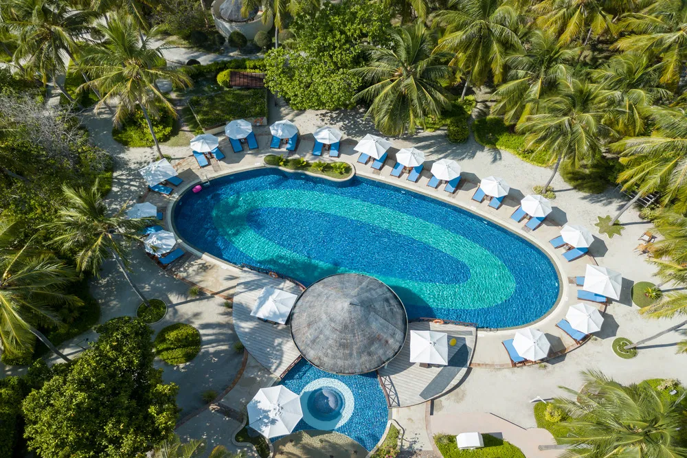 The pool from above, with loungers, parasols and the thatched bar