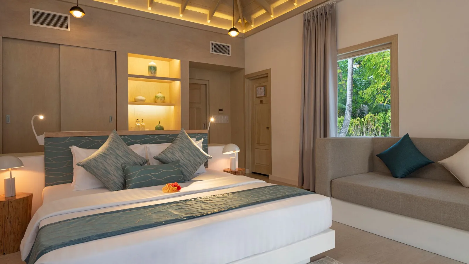 A Beach Villa, its bed, sofa and window onto the garden