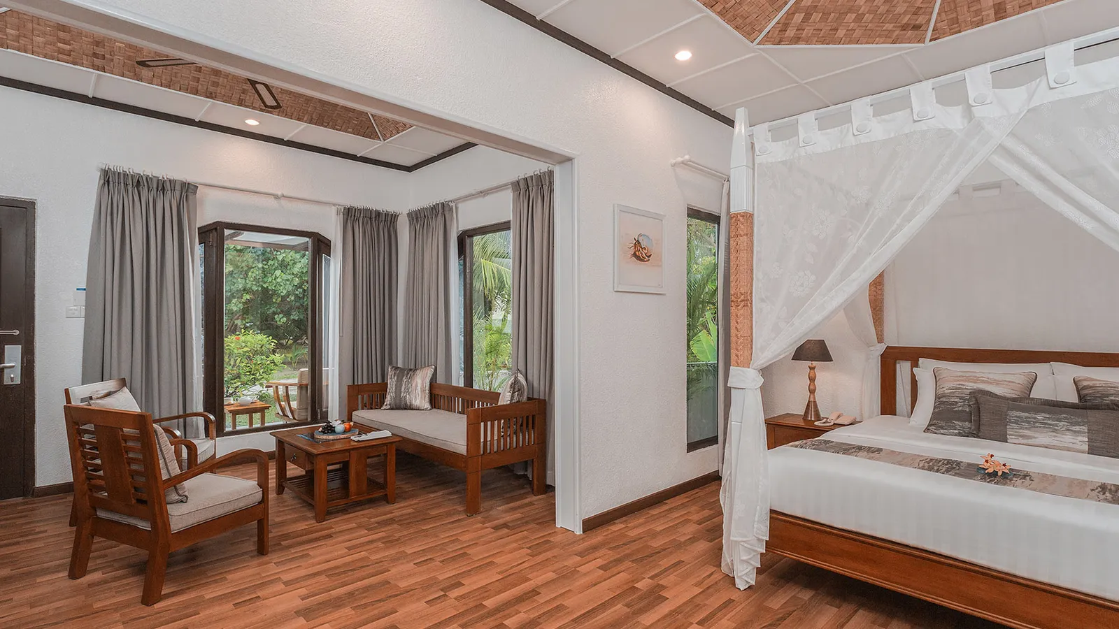 A Deluxe Beachfront Room, its sitting area and the bed with its net