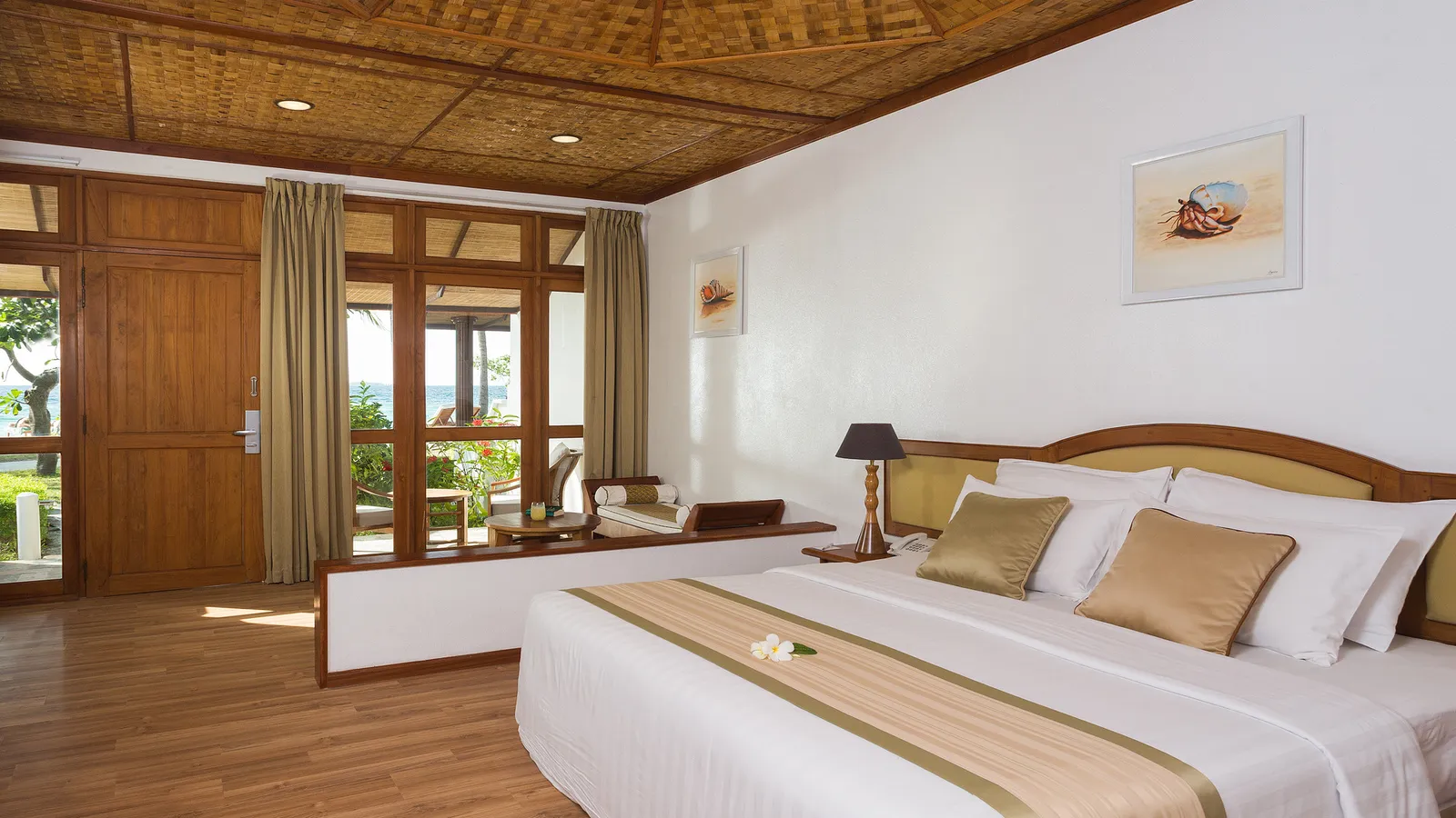 A Standard Beachfront Room, its bed and woven ceiling, the door to the veranda