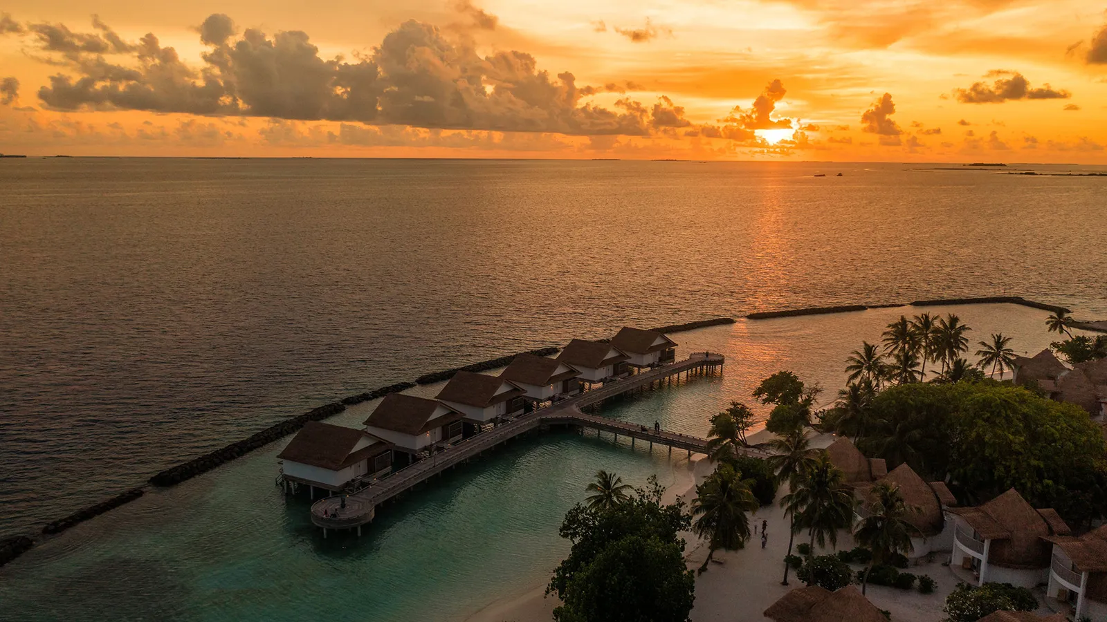 The overwater villas and the tip of the island from the air, at sunset
