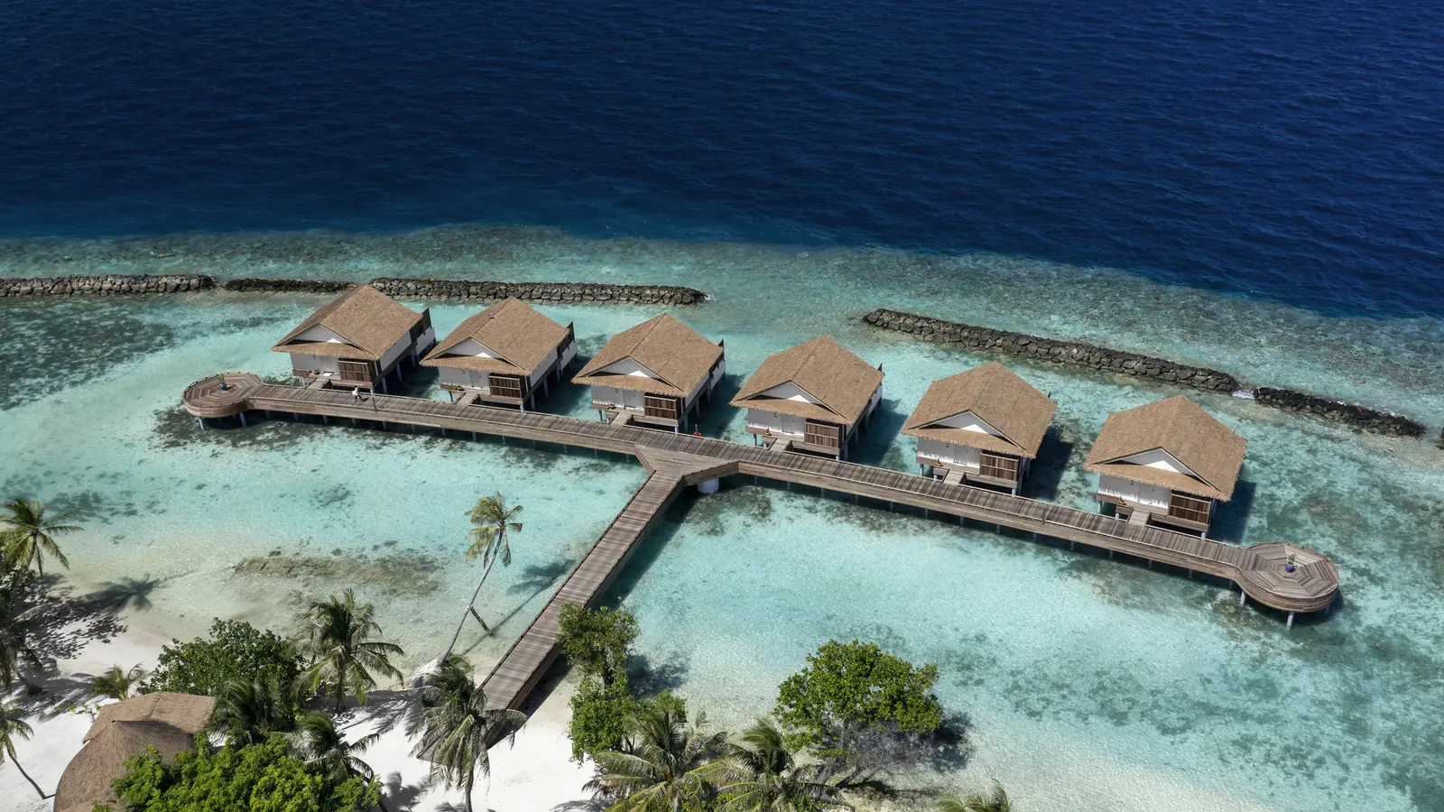 The 6 Sunset Water Villas from above, in a row on the jetty over the lagoon