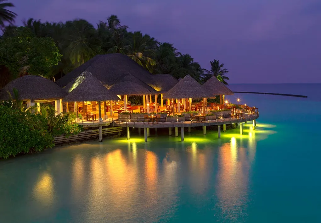Cayenne Grill lit up over the lagoon at dusk