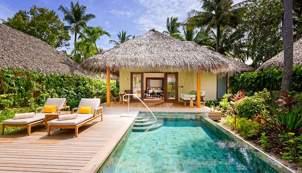 The Baros Residence pool in its garden, in front of the thatched pavilion