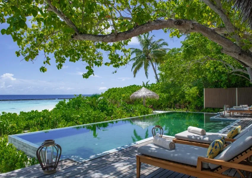 The Two-bedroom Retreat’s pool under the trees, the sea beyond the hedge