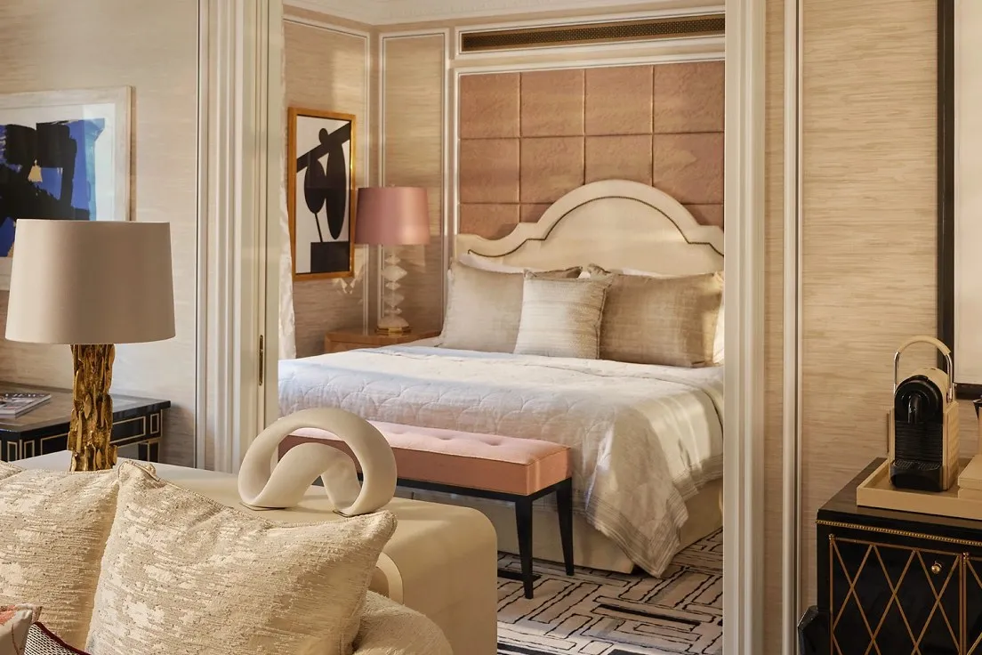 A City Suite: an armchair in the sitting area, and the bed beyond a mirrored doorway
