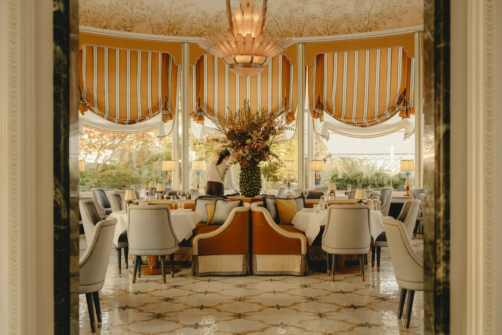Marguita’s rotunda: striped blinds on tall windows, a gilded ceiling and round tables laid for dinner