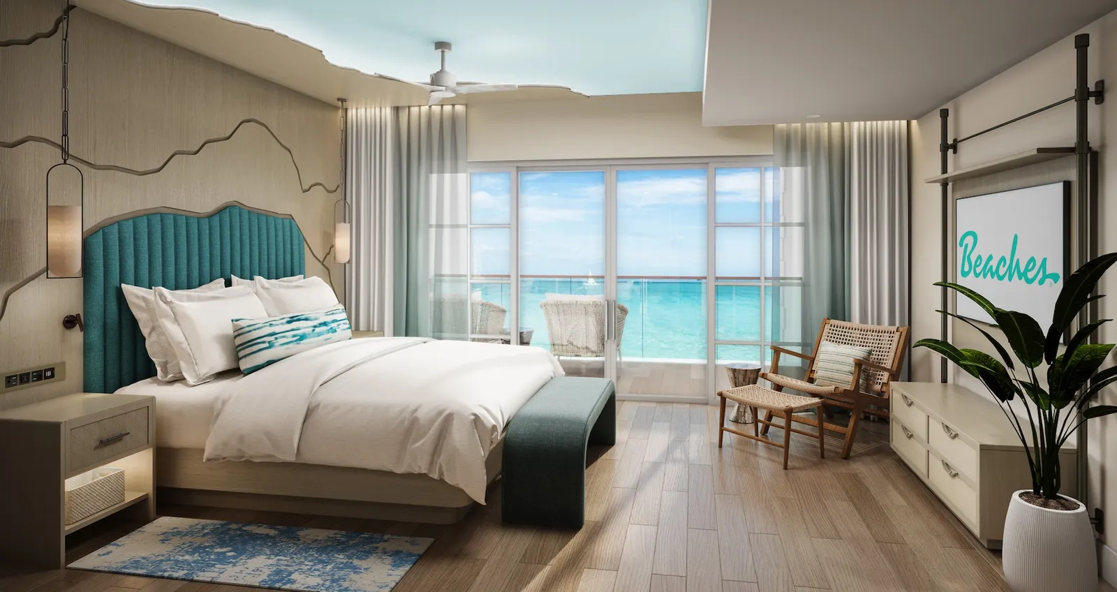 A bedroom with a teal headboard, a bench and a wall of glass onto the turquoise sea.