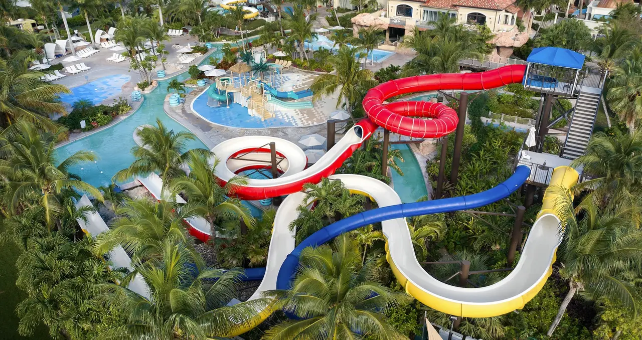 The water park’s slides from above: red, blue, yellow and white tubes spiralling down among the palms towards the pools.