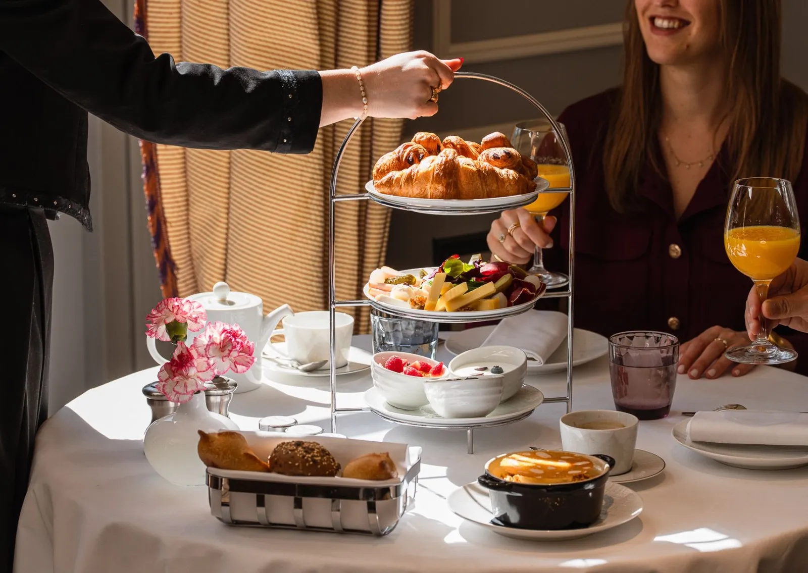 A stand of pastries and an orange juice served at the table