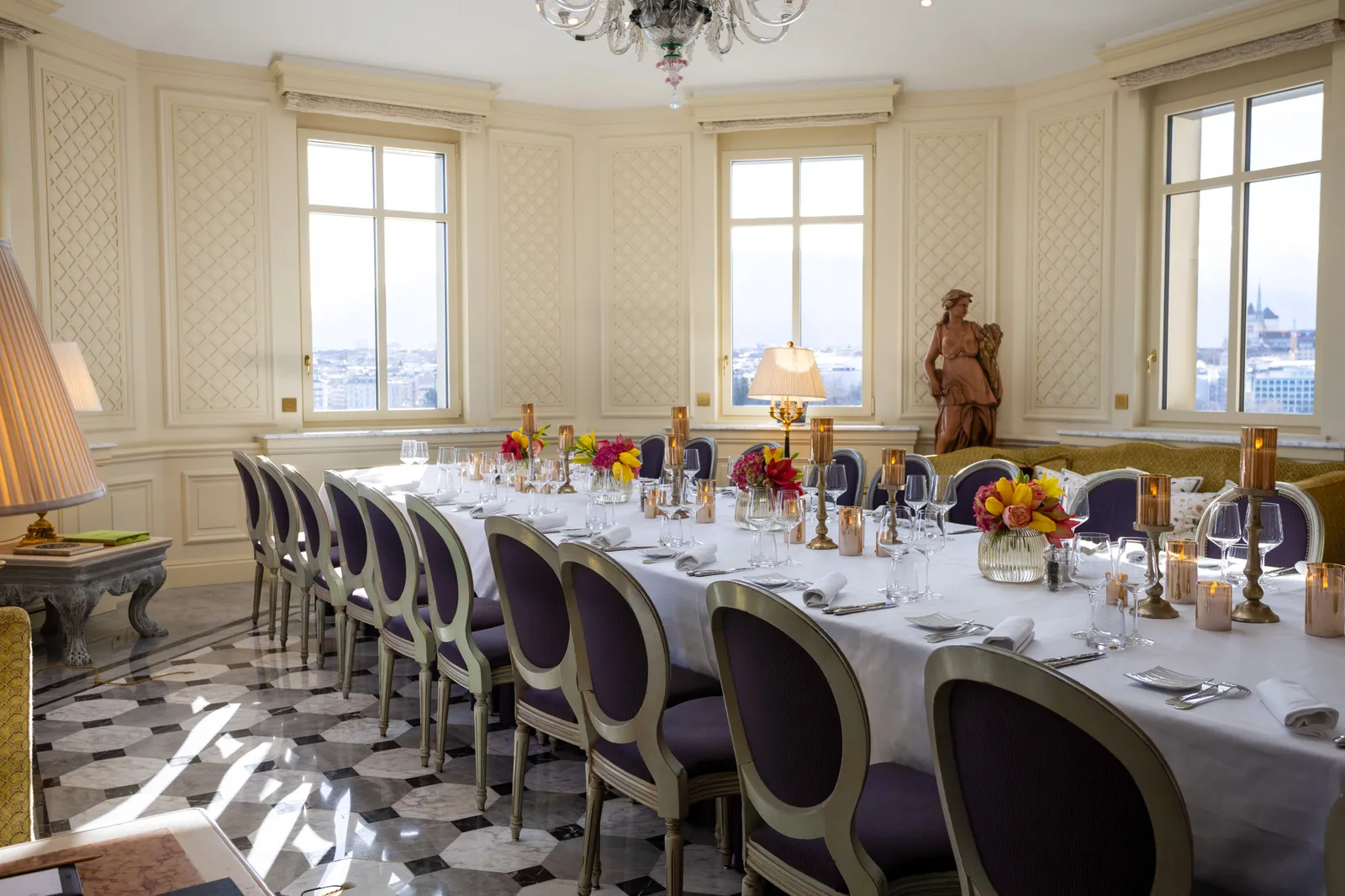 A salon set for a banquet, with statues and a domed ceiling