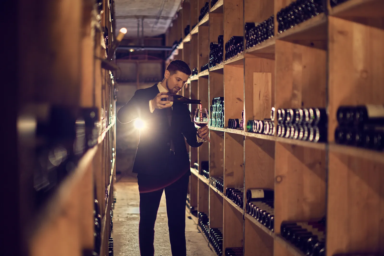A sommelier among the bottle racks of the wine cellar
