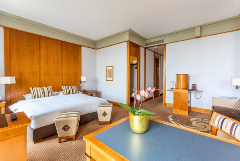 Il letto della Deluxe Room davanti alla parete di legno