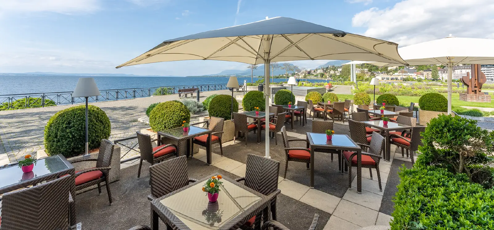 La terrazza della Véranda-Bar, con gli ombrelloni davanti al lago
