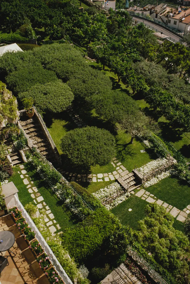 The terraced gardens seen from above: lawns, umbrella pines and stone paths.