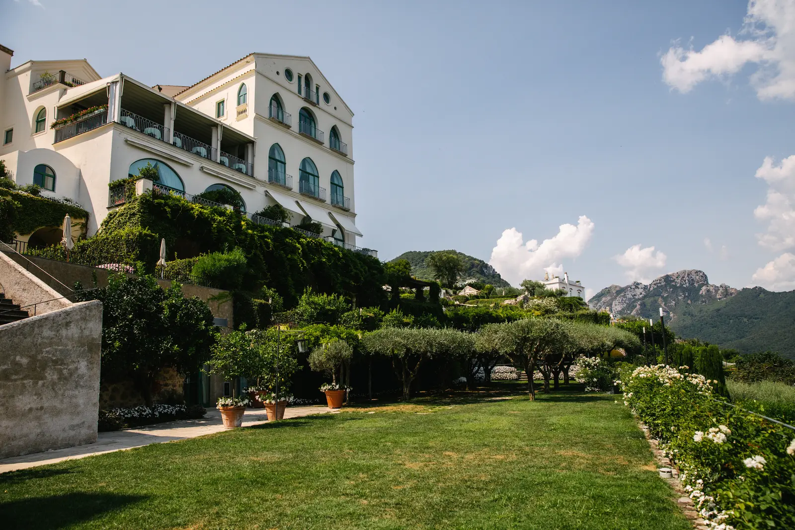 Caruso’s white palace above the lawn and terraced gardens, with the mountains behind.