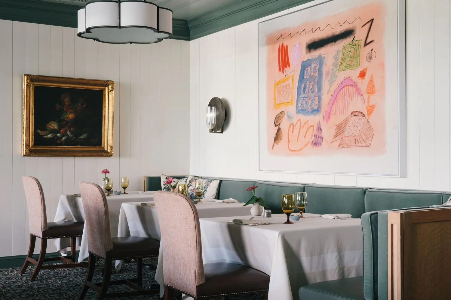 The Dogwood’s dining room: white panelled walls, a large pink abstract canvas, the green banquette along the wall and tables in white cloths.