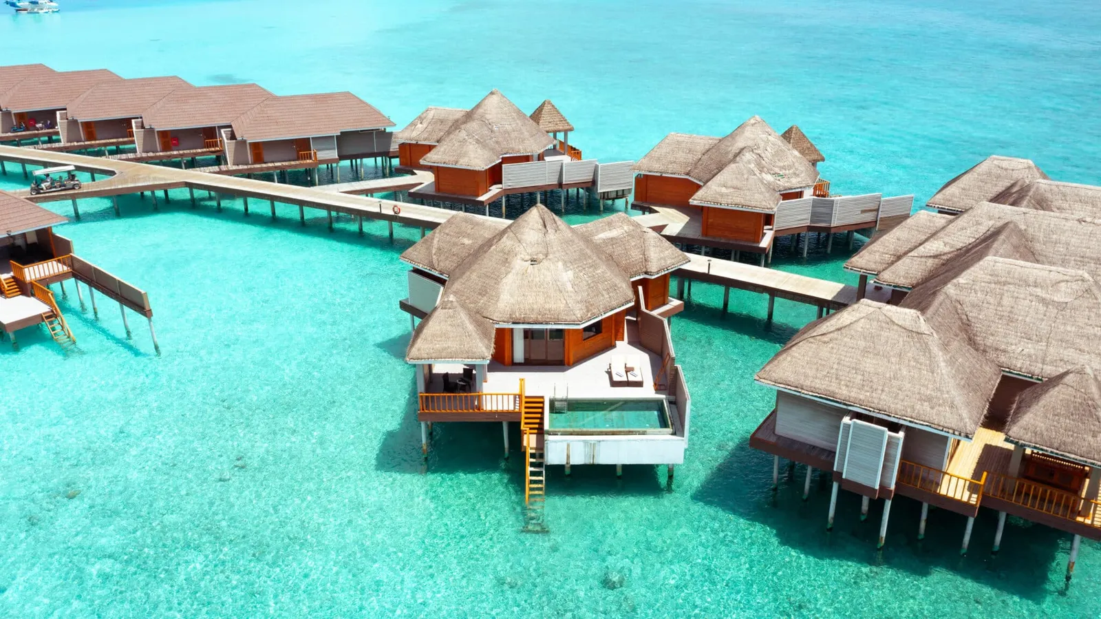 Overwater villas with pools, seen from above.