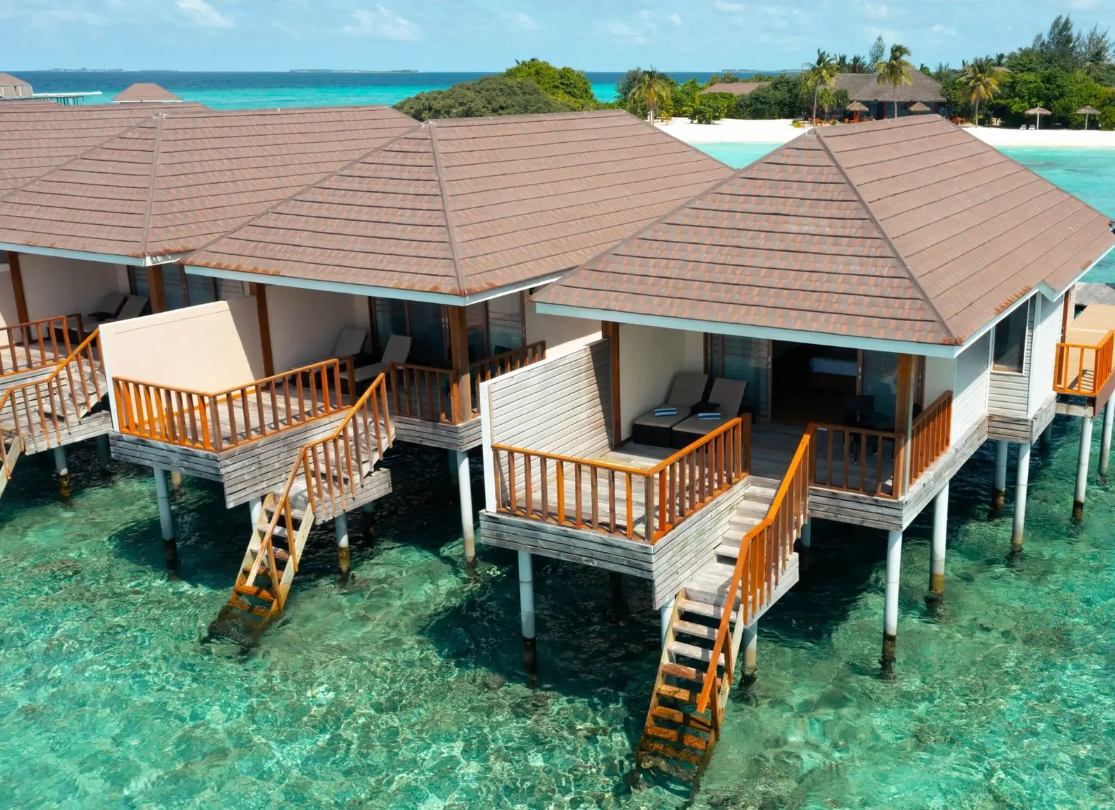 Overwater villa terraces with steps towards the lagoon.