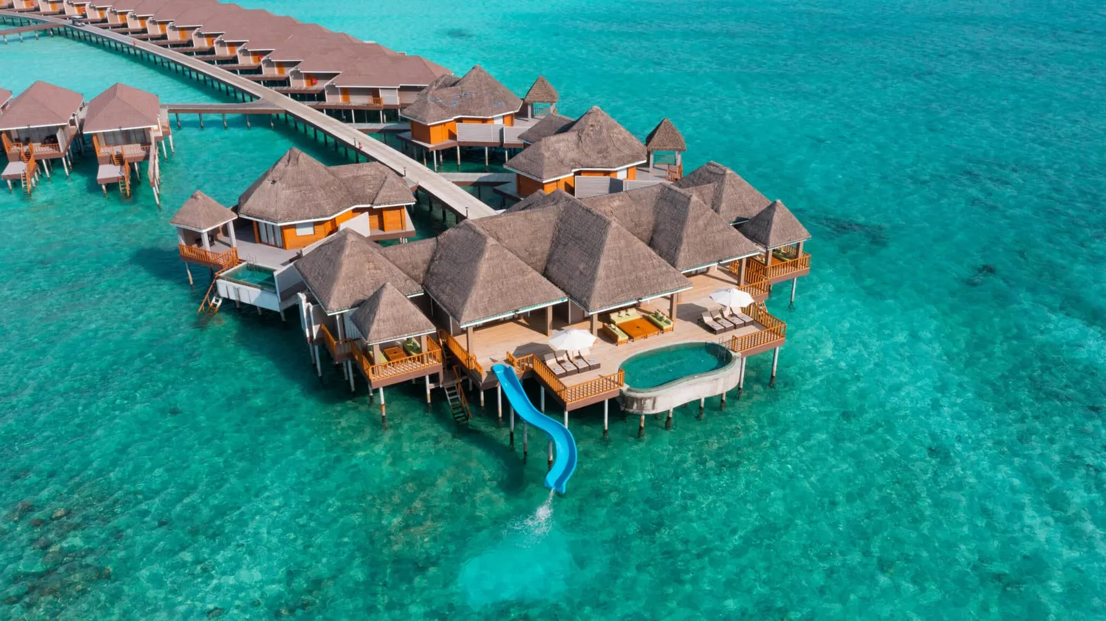 The overwater villa with a pool and slide, seen from above.
