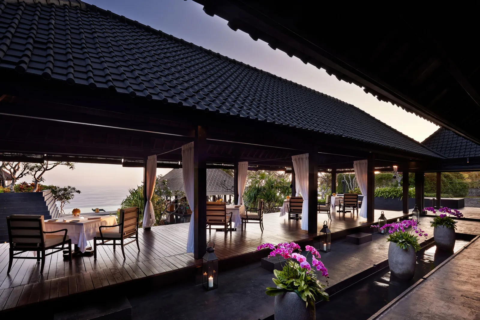 Il Ristorante’s covered terrace: tables laid for 2, pink orchids and the sea on the horizon.