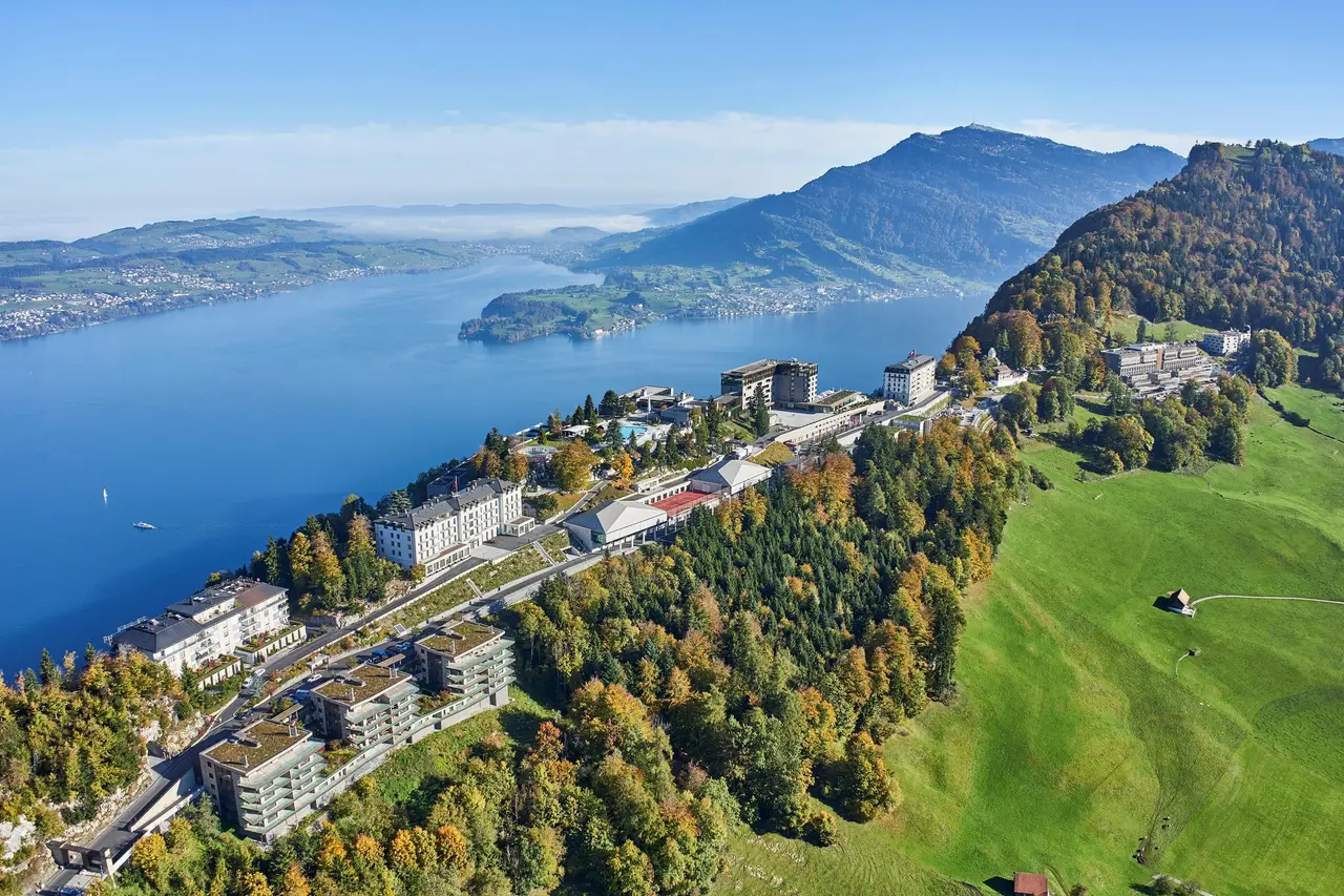 The resort in autumn on the ridge above Lake Lucerne: the hotels, the residences and the pastures, with the lake and a long mountain behind