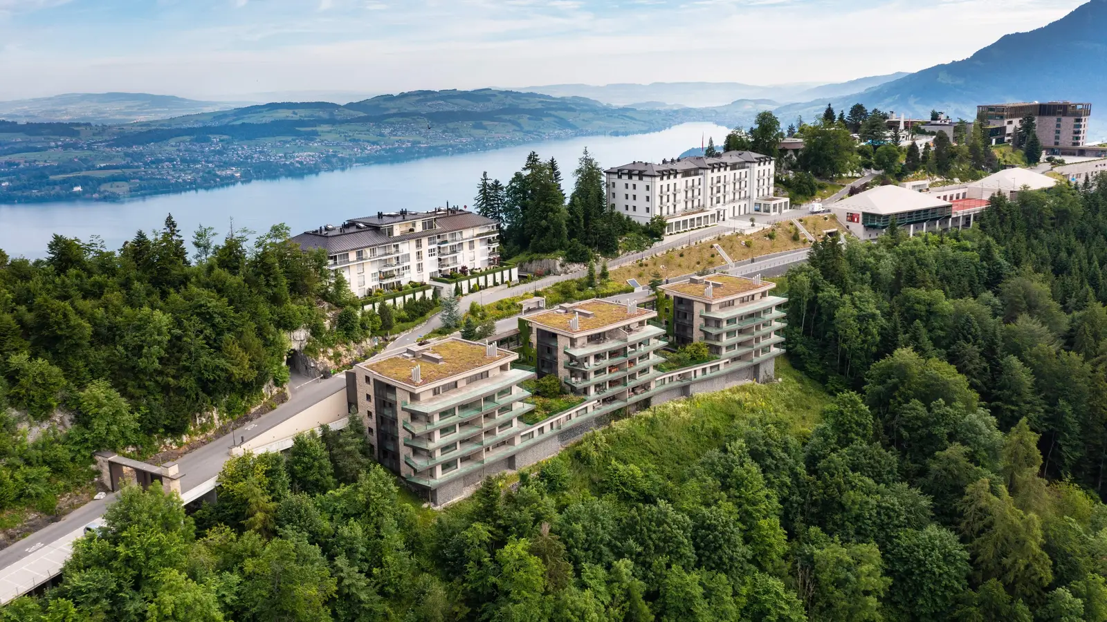 The resort from the air on its wooded ridge: the white Palace, the low residence blocks and the Contemporary’s tower, with the lake stretching away behind