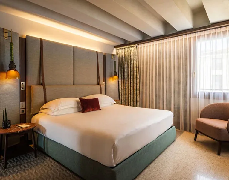 A Junior Suite under the beams, with the bed and an armchair