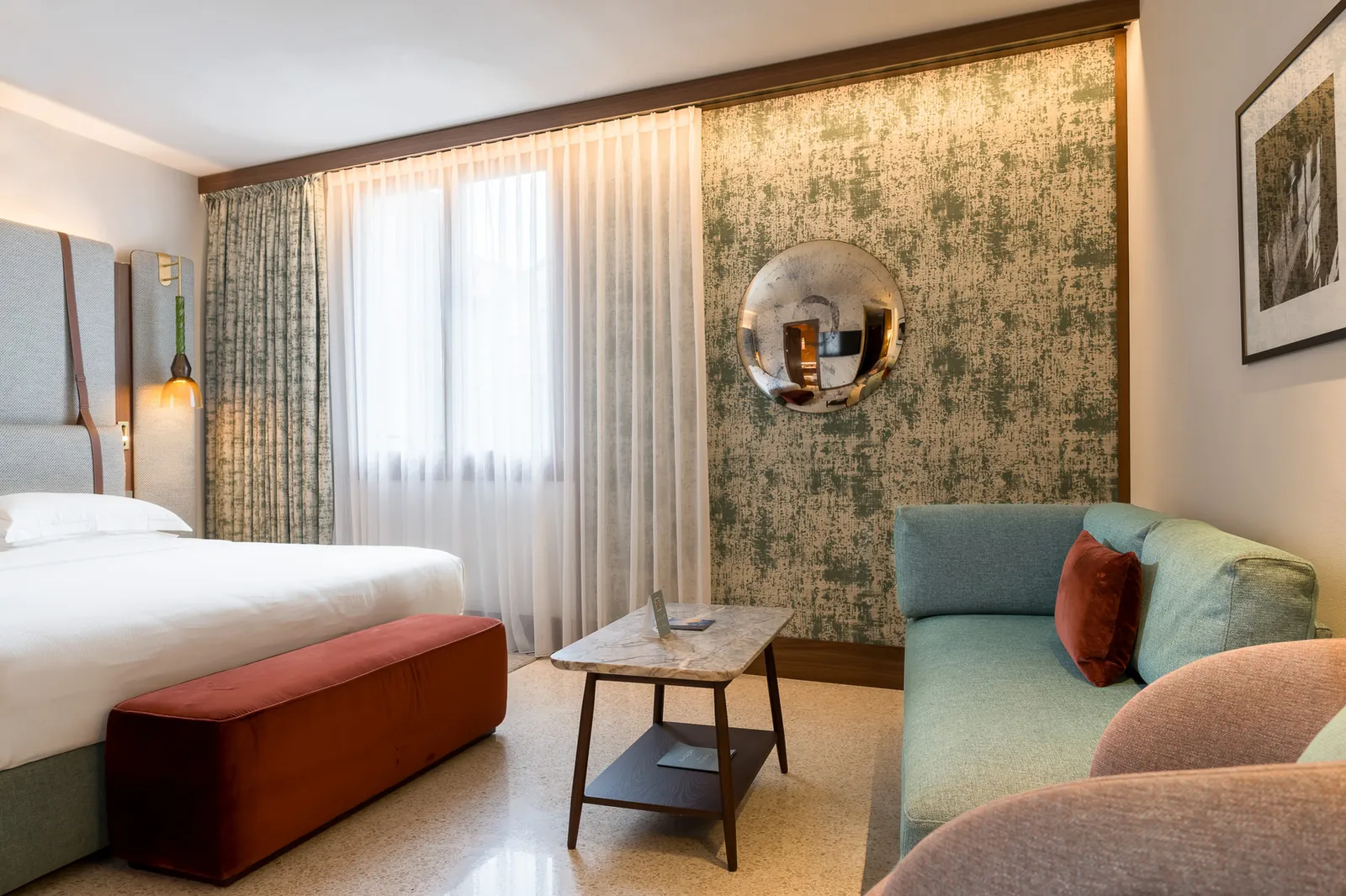 A Premium Junior Suite, with the sofa, the armchairs and walls lined in green fabric