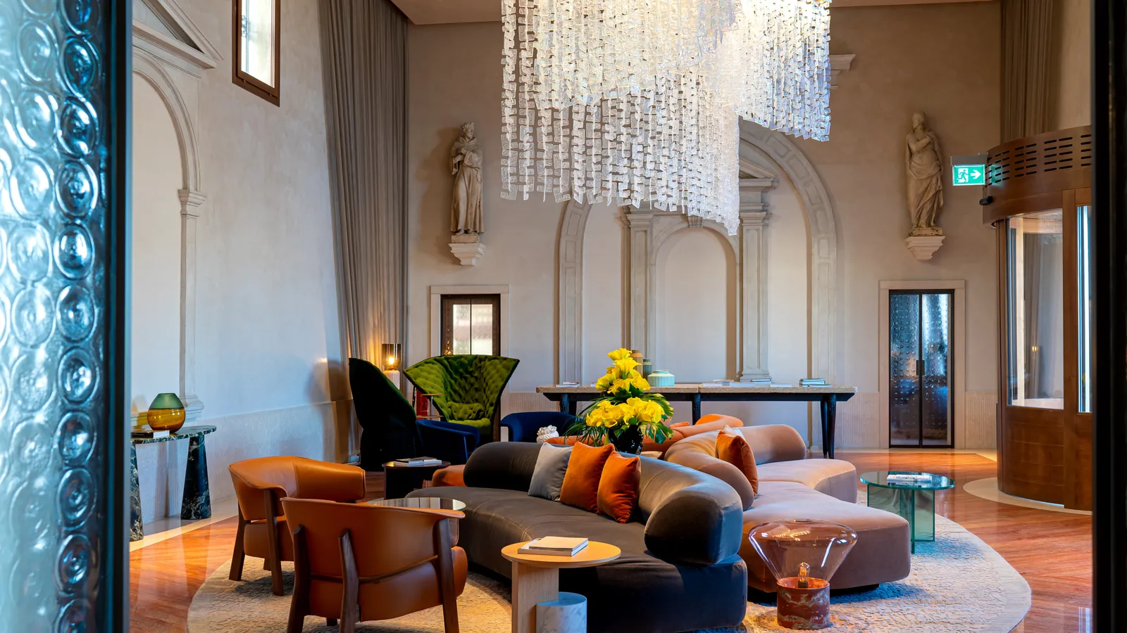The lobby in the former chapel, with the great glass chandelier, the statues and the curved sofa