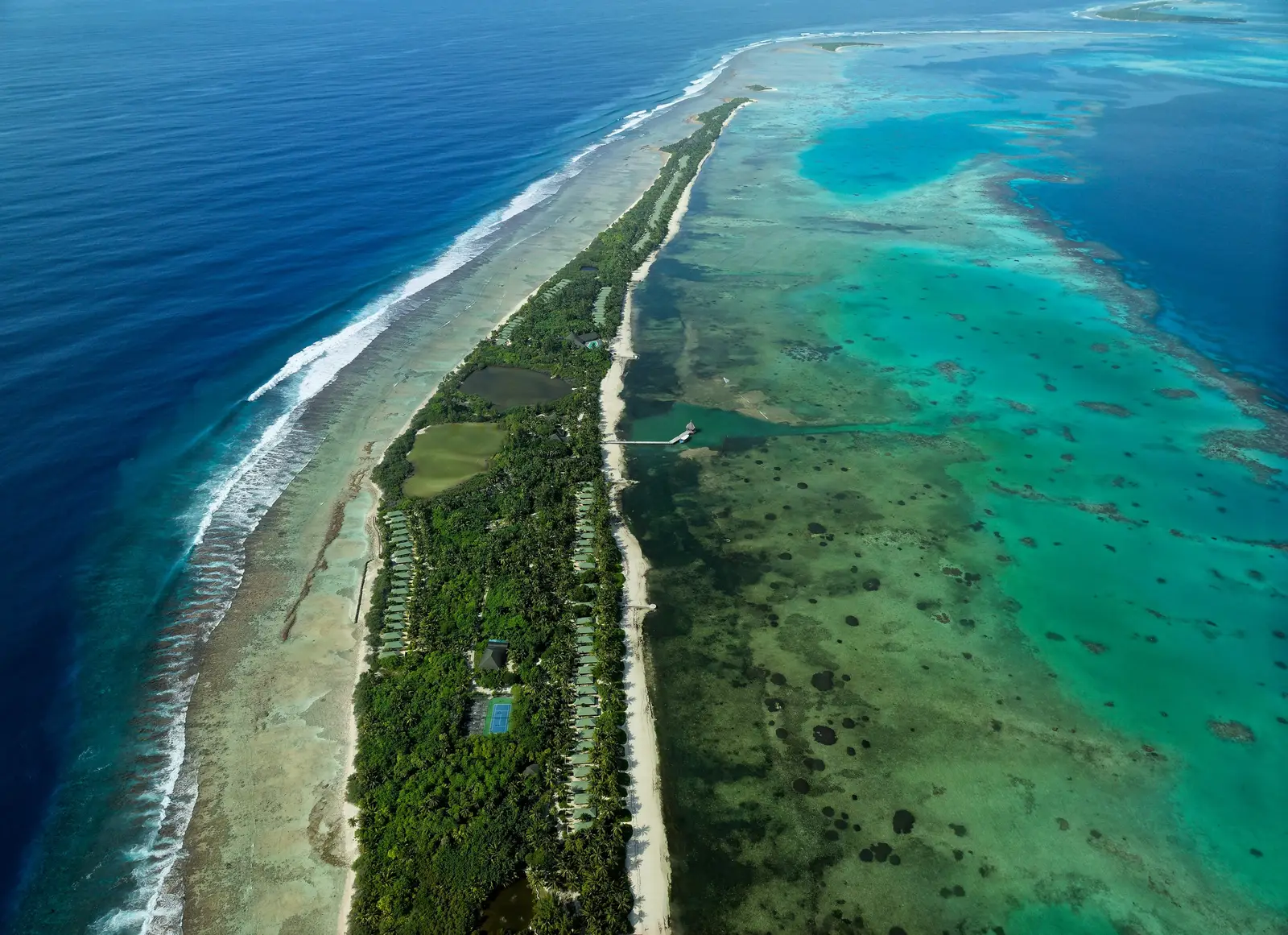 Herathera from the air: the long, narrow island between the ocean and the turquoise lagoon