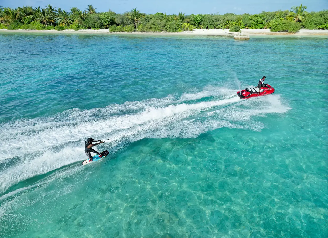 A jet ski tows a water-skier across the turquoise lagoon
