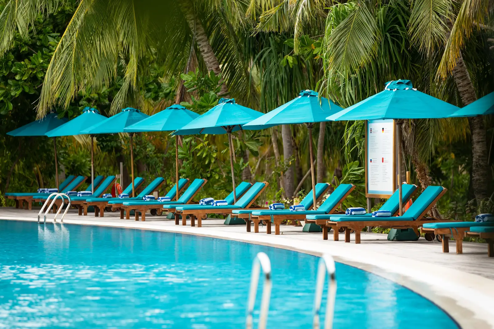 The pool with turquoise umbrellas among the palms