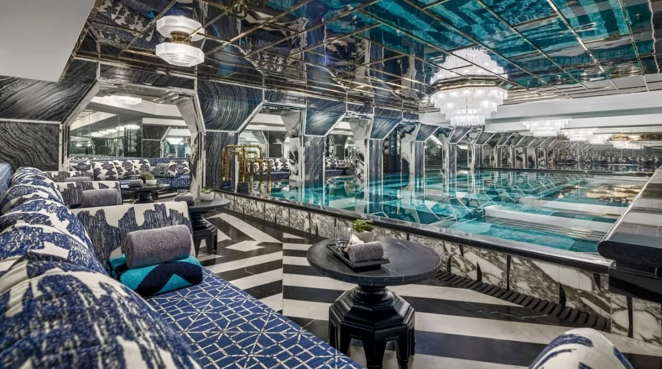 La Grotta, the indoor pool under a mirrored ceiling, blue-and-white daybeds beside it