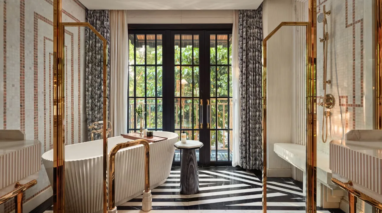 A Capella Suite bathroom: freestanding tub, black-and-white striped floor, French windows