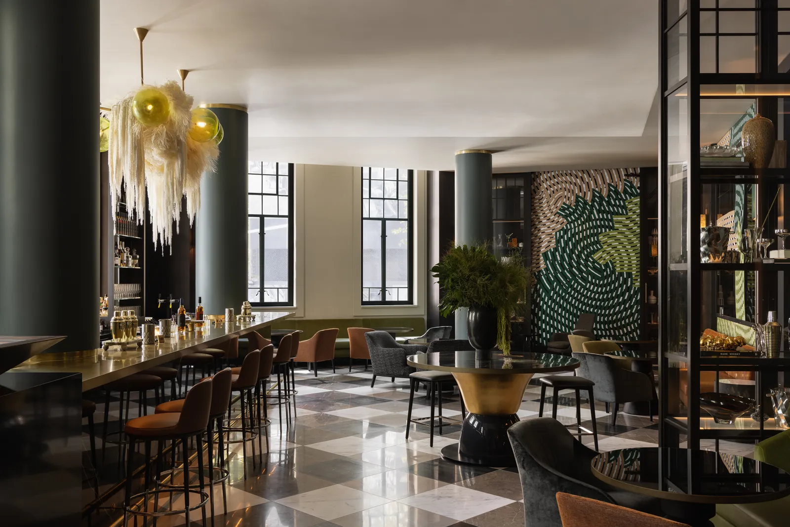 McRae Bar: a long counter with leather stools, a feathered chandelier and a green swirling mural