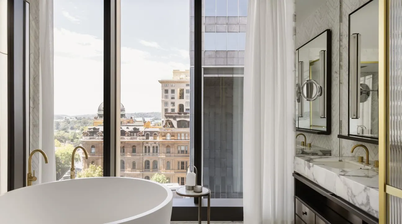 The Capella Suite’s bathroom: a freestanding bath by a window onto sandstone rooftops