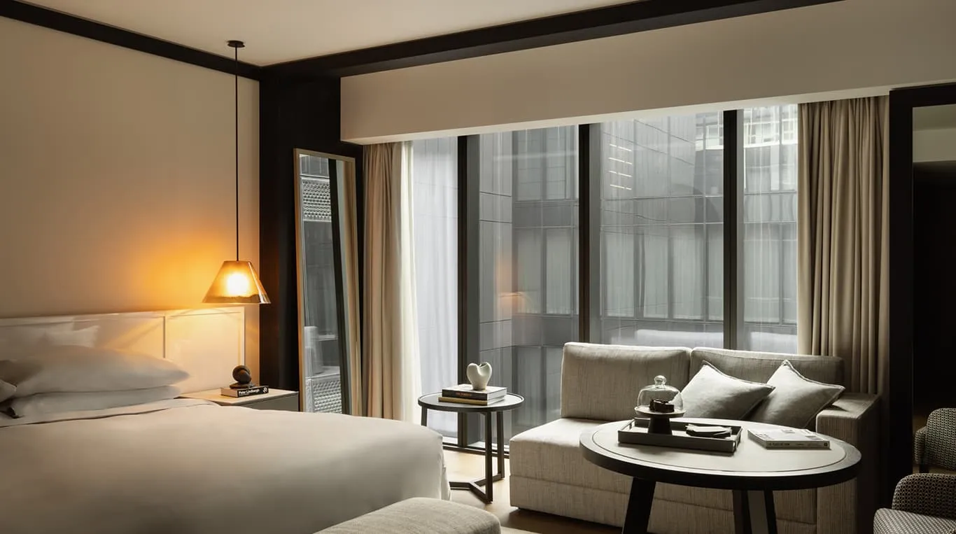 A Deluxe Accessible Room: a king bed under a pendant lamp, a sofa by a wide window