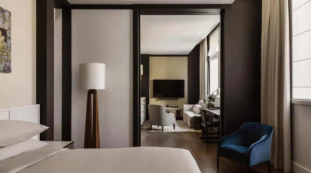 The Deluxe Accessible Suite: the bed in front, the sitting room through a wide doorway
