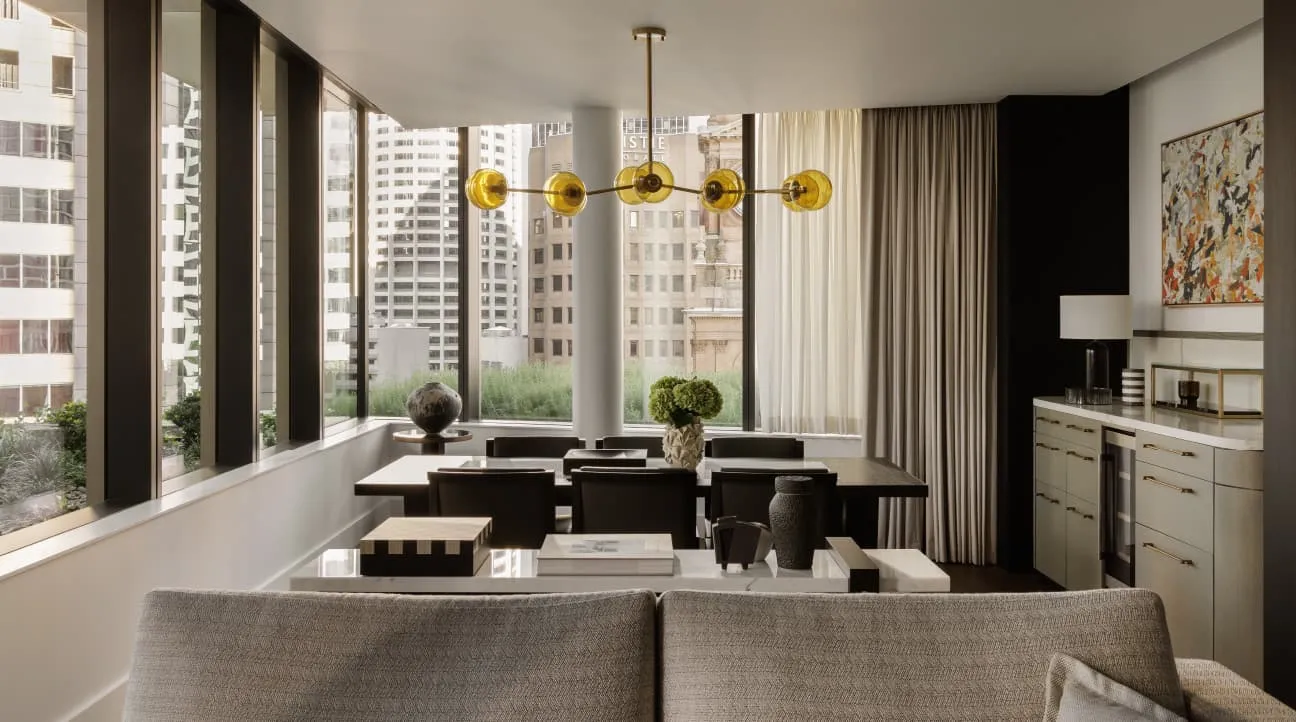 The Farrer Suite: a dining table, a sofa and windows onto the city’s towers