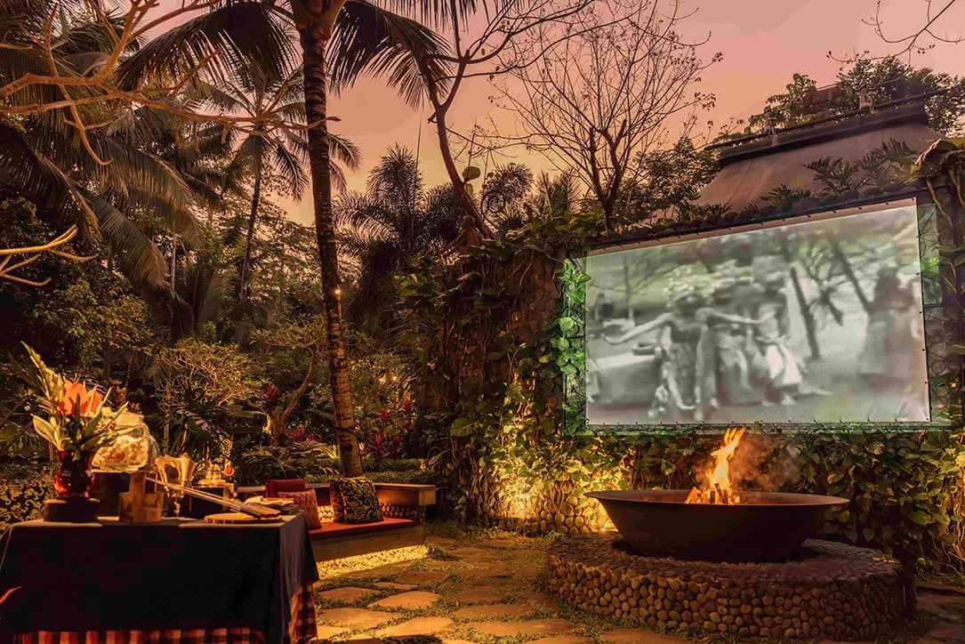 The Campfire at sunset: the brazier alight, coloured cushions round it and a black-and-white silent film on the screen among the trees.