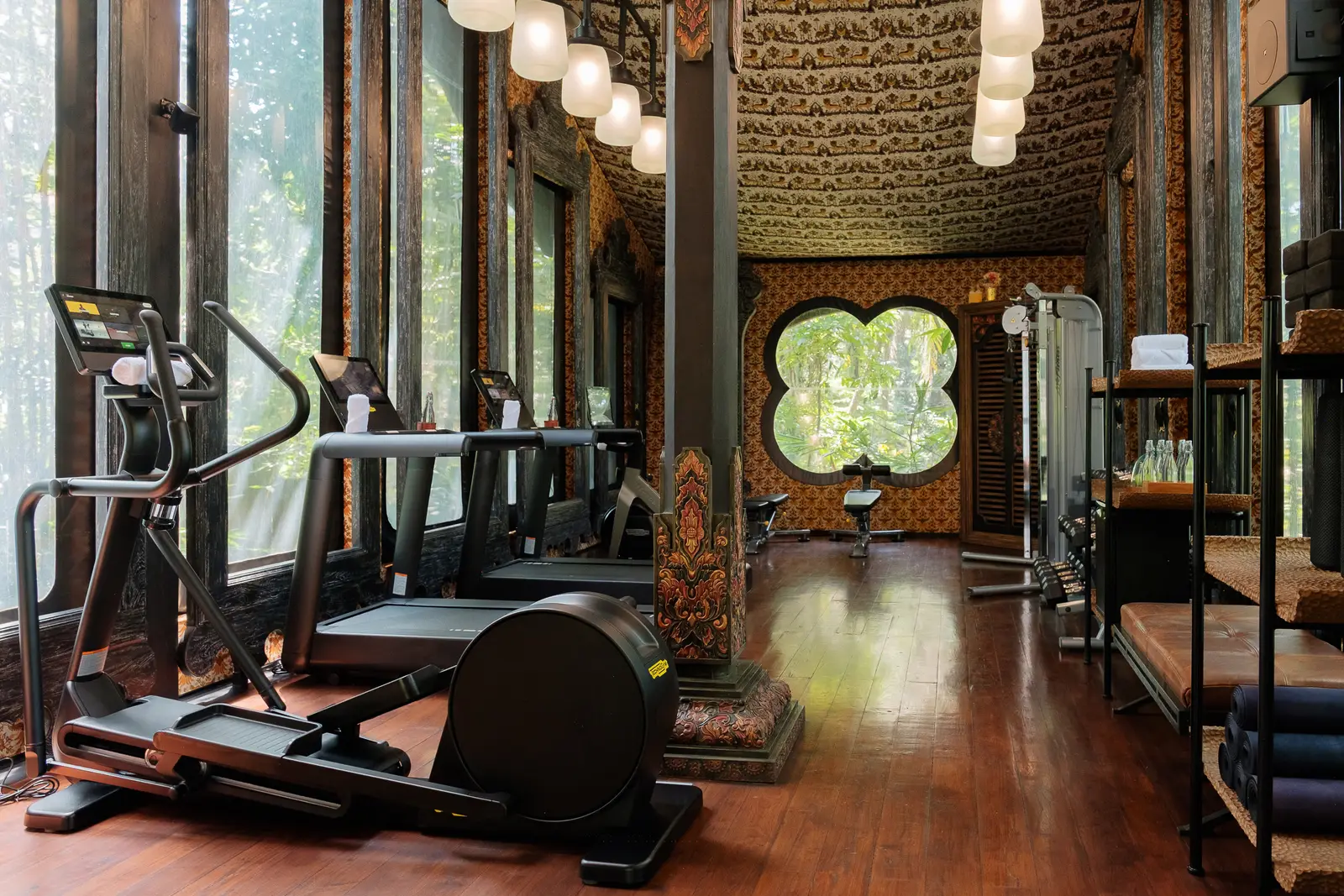 The Armory, the tented gym: treadmills and machines along the glass, a quatrefoil window at the far end.