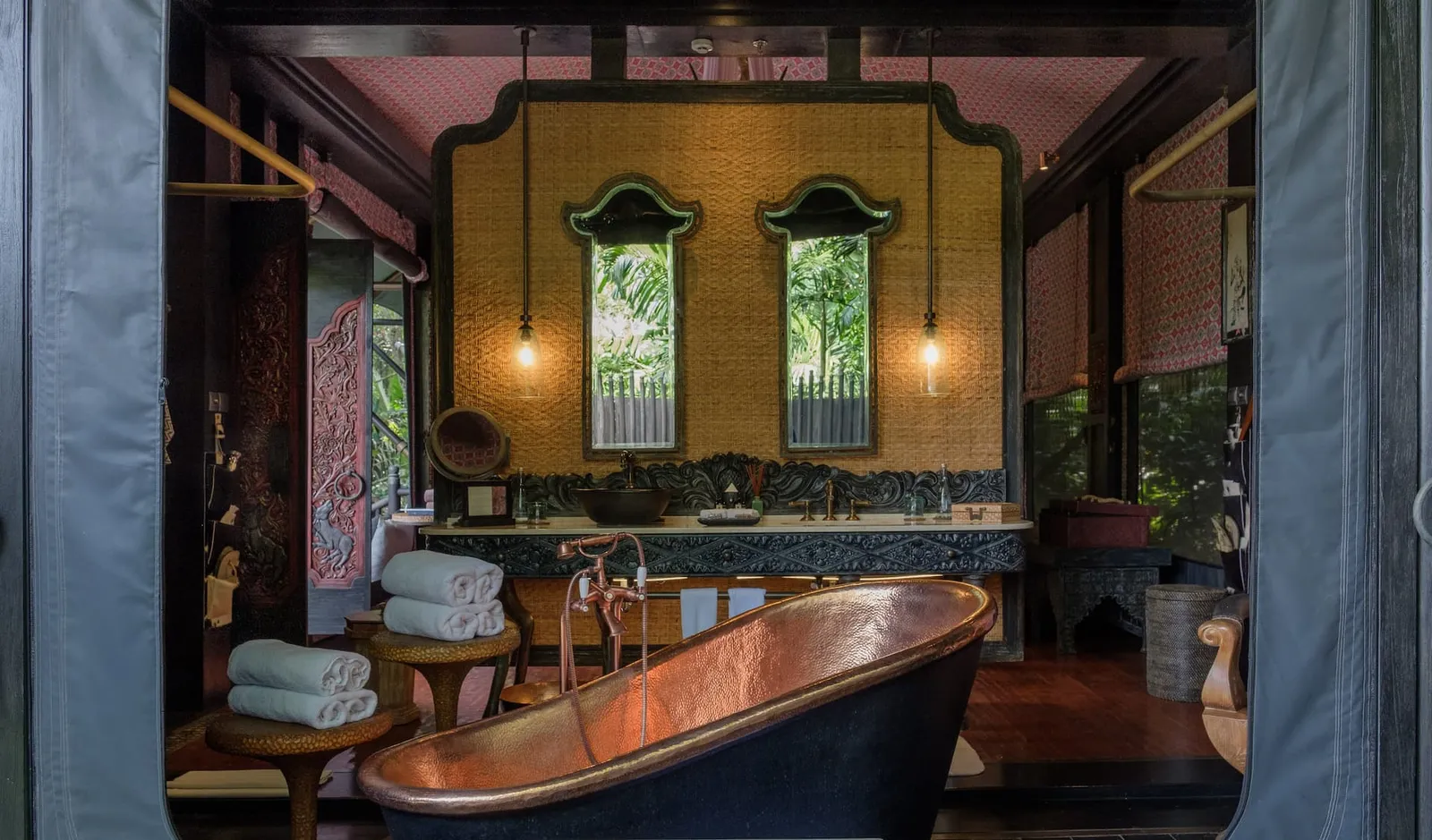 A Forest Tent’s copper bath in front of the basin, between canvas walls rolled up onto the greenery.
