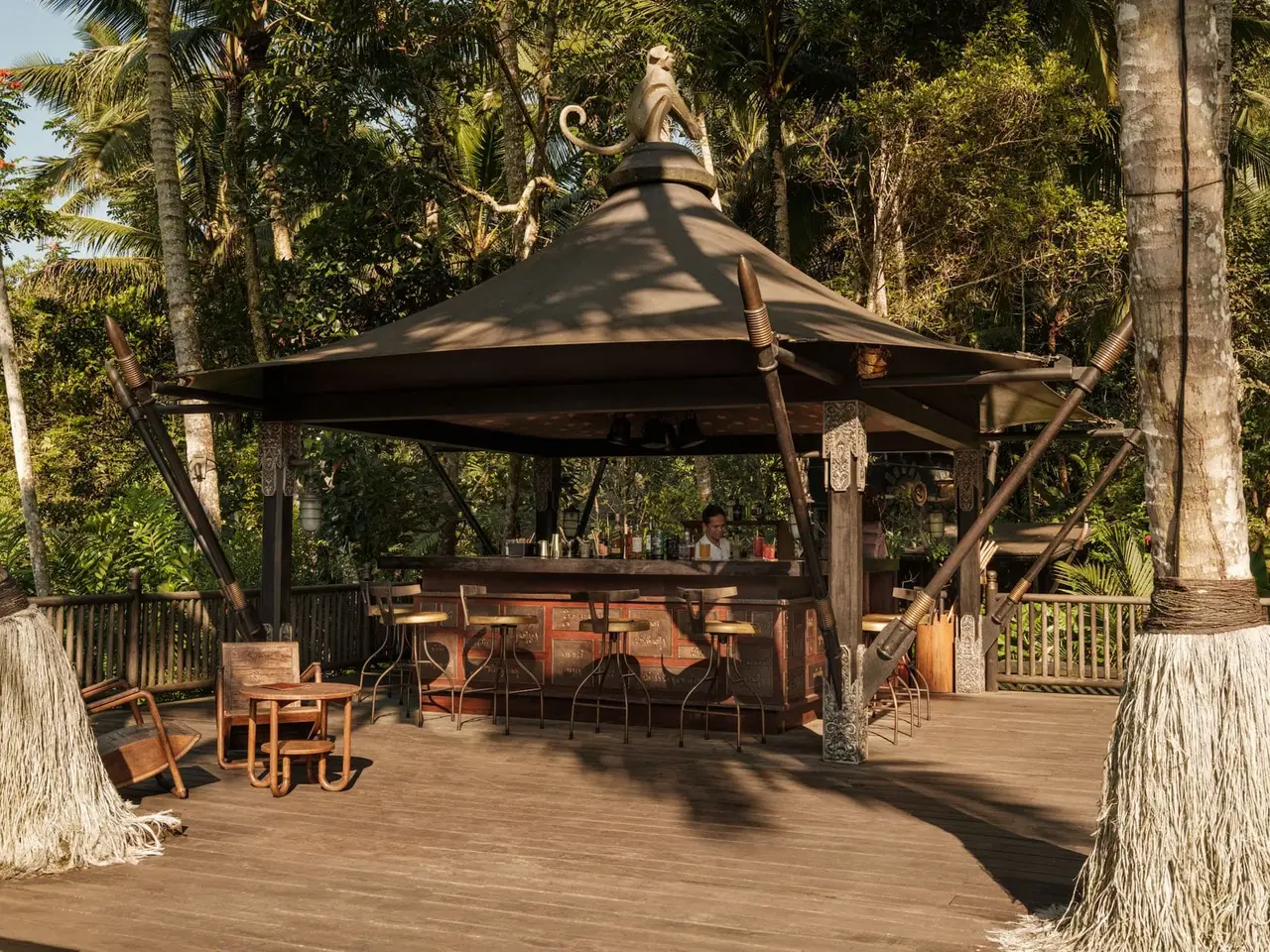The Mortar & Pestle Bar: a canvas pavilion on the wooden deck by the pool, stools at the counter and low chairs.