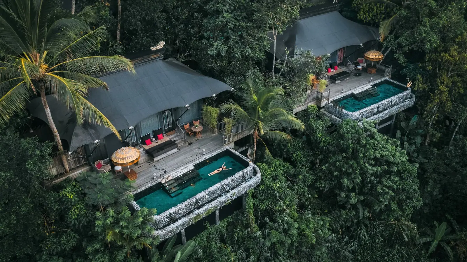 2 Keliki Tents from above: the canvas roofs, the wooden decks with parasols and the infinity pools facing the valley.