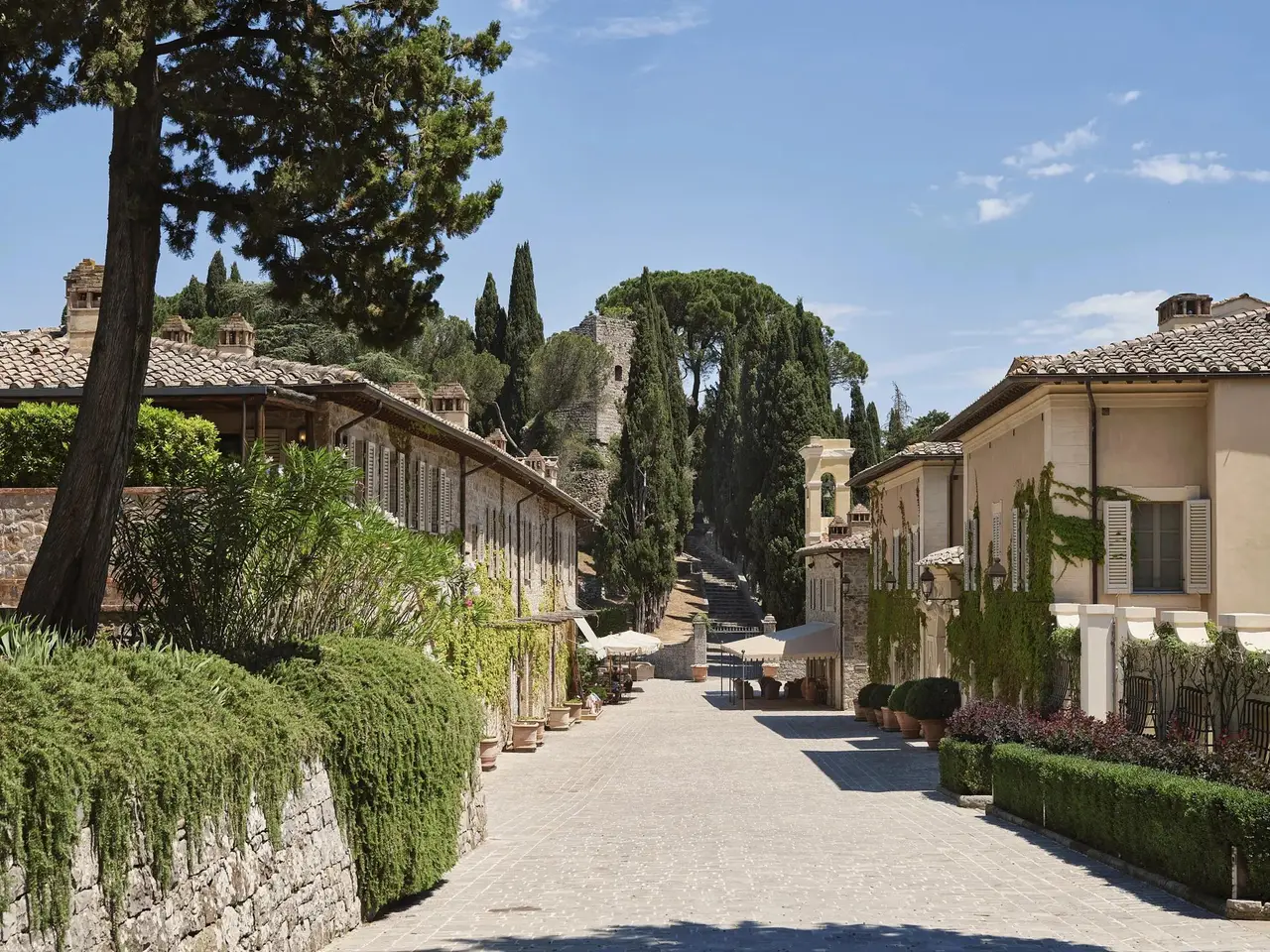 The borgo’s stone-paved avenue between the low houses, the hanging gardens and the cypresses.