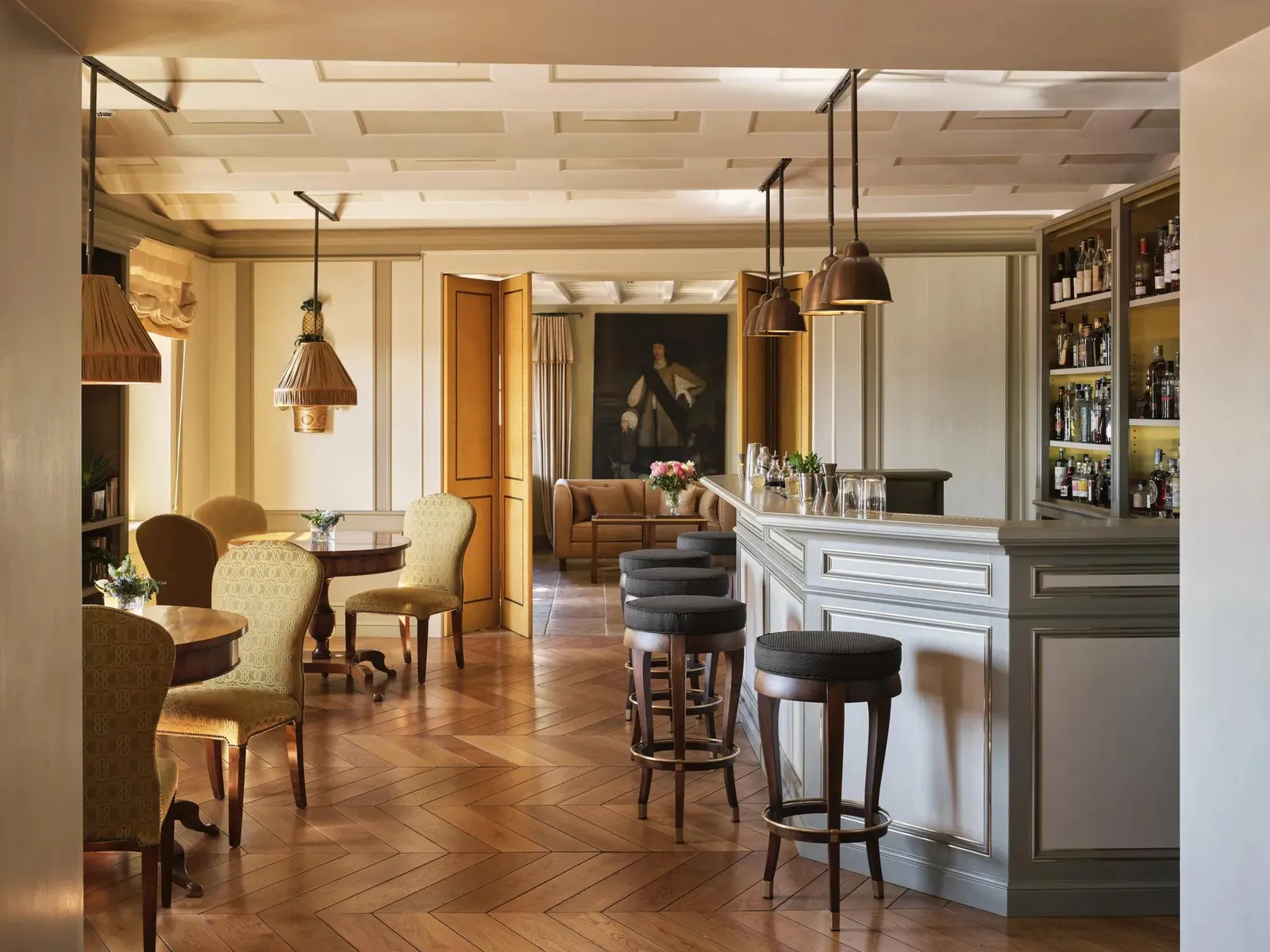 The Lobby Bar, with its counter, high stools, armchairs and a portrait on the far wall.