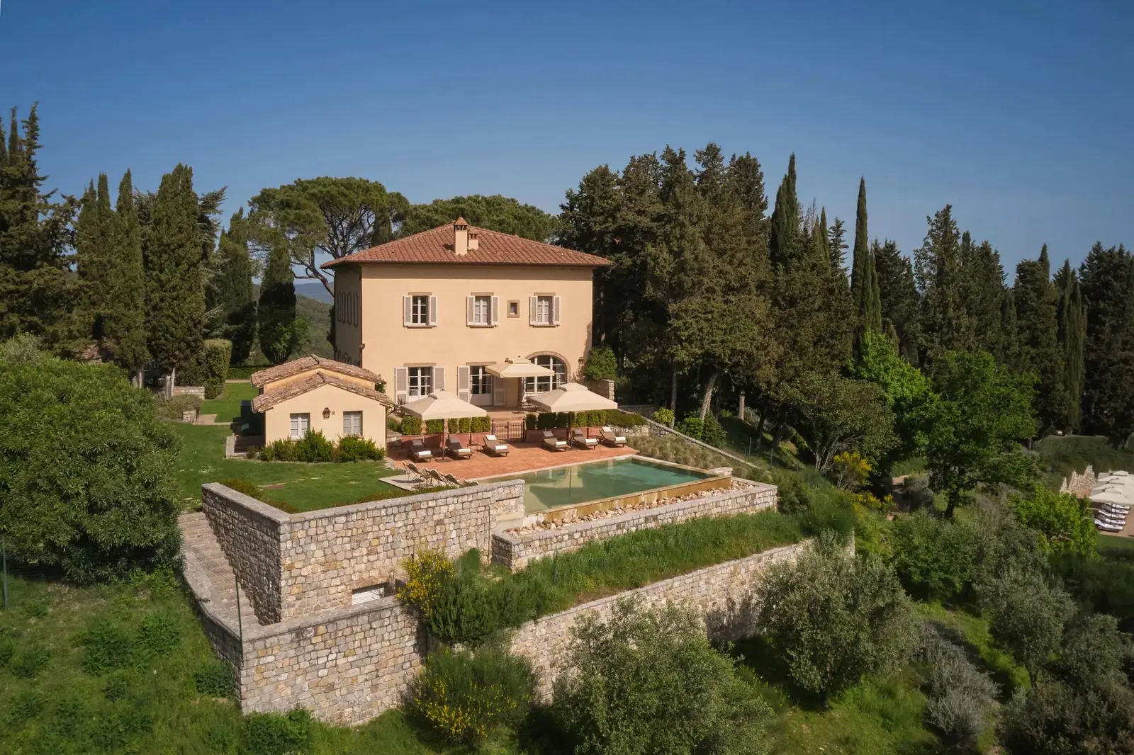 Villa Chiusa, the sand-coloured house on the hill, its pool on the stone terrace below the house.